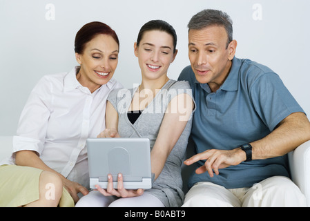 Teen Mädchen beobachten tragbaren DVD-Player mit ihren Eltern, alle Lächeln auf den Lippen Stockfoto