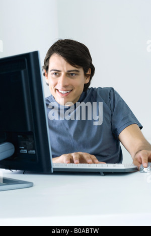 Mann mit Desktop-Computer, Lächeln Stockfoto