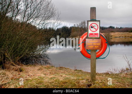 Ein Warnschild mit einem Rettungsring, Warnung vor den Gefahren des Tiefenwassers und schwimmen zu verbieten. Stockfoto