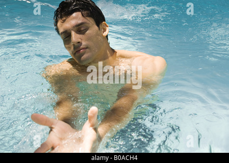 Mann im Schwimmbad, geschlossenen Augen und ausgestreckten Armen Stockfoto