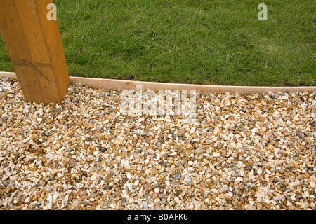 Weg mit hölzernen Rasenkante und Pergola Basis Kies Stockfoto