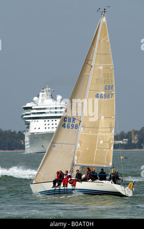 Eine Yacht und ein Kreuzfahrtschiff mit Down auf dem Solent England UK Stockfoto