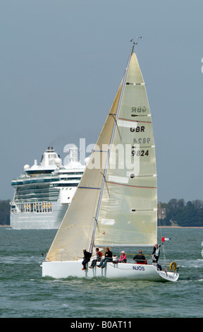 Eine Yacht und ein Kreuzfahrtschiff mit Down auf dem Solent England UK Stockfoto