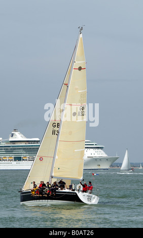 Eine Yacht und ein Kreuzfahrtschiff mit Down auf dem Solent England UK Stockfoto