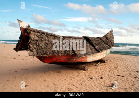 Traditionellen hölzernen Fischerboot oder Vallom fallenden strohgedeckten Dach zum Schutz gemacht von Kokosnuss Palmen am Strand Stockfoto