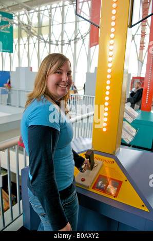 Ein junges Mädchen drückt den Griff eines Kraft-Tests am Pacific Science Center, Seattle, Washington, Vereinigte Staaten von Amerika. Stockfoto