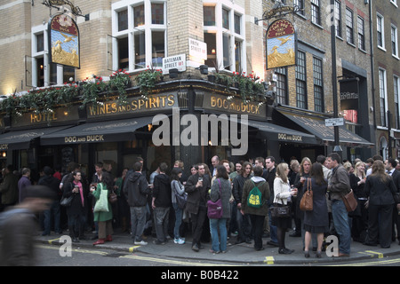 Trinker spill heraus auf der Straße vor dem Hund und Ente Pub in Soho in London Stockfoto