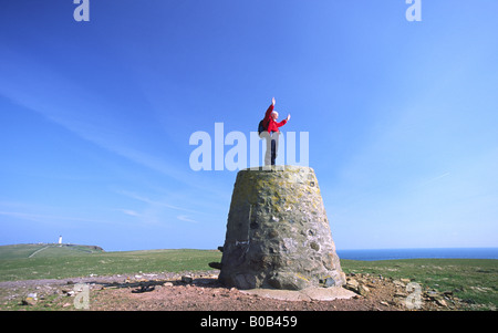 Coastal walks Walking den Mull of Galloway Walker am oberen Kennedy Cairn mit Leuchtturm hinter Rhins of Galloway Scotland UK Stockfoto