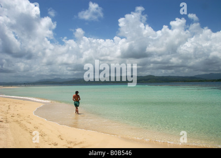 Eine Frau kommt an einem Strand im tropischen Paradies auf den San Blas Inseln von Panama. Stockfoto