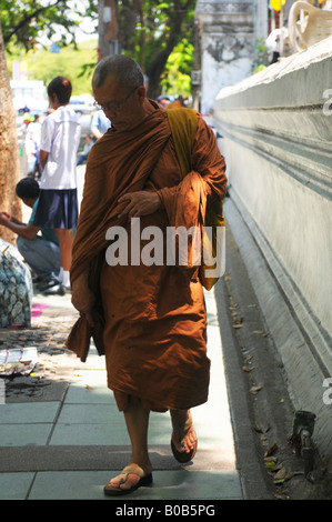 Mönch auf Straße in Bangkok, vorbei an Amulett Händler auf dem Bürgersteig, Bangkok, thailand Stockfoto