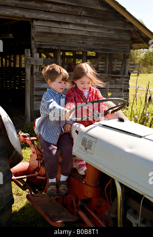 SOUTH CAROLINA YORK Young Bruder und Schwester sitzen in den Fahrersitz von einem alten Ford 9N Traktor vorgibt, es zu fahren Stockfoto