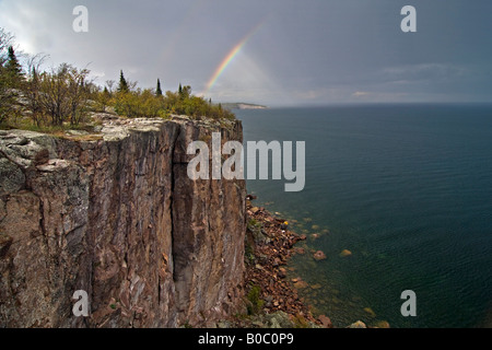 Ein Regenbogen erscheint während eines Gewitters an Palisade Kopf und Schaufel Punkt im Tettegouche State Park auf Minnesota North Shore Stockfoto