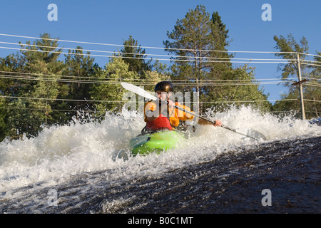 Ein Wildwasser-Kajakfahrer senkt sich einen Wasserfall über Dead River in der Nähe von Marquette, Michigan Stockfoto