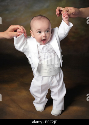 biracial Baby junge Stand mit Hilfe von Eltern Stockfoto