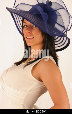 Frau trägt weißes Kleid und blauen Hut. Stockfoto
