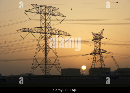 Strommasten und Öltanks im Abendlicht, Dubai, Vereinigte Arabische Emirate Stockfoto