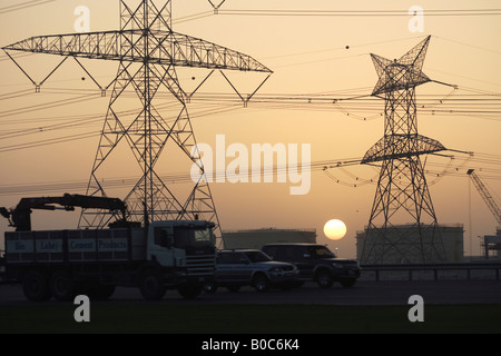 Strommasten und Öltanks im Abendlicht, Dubai, Vereinigte Arabische Emirate Stockfoto