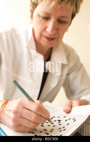 Frau macht Kreuzworträtsel Stockfoto