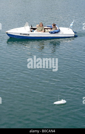 Familie in einem Motorboot kontrolliert spielen mit einem Radio Boot Stockfoto