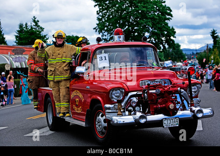 Bild einer Gruppe von Feuerwehrleuten in einheitlichen Reiten auf der Außenseite einer antiken Feuerwehrauto Stockfoto