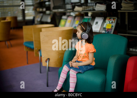 Zentrale Bibliothek Palmerston North New Zealand vier Jahre alten Mädchen hört Radiosendungen über Kopfhörer Stockfoto