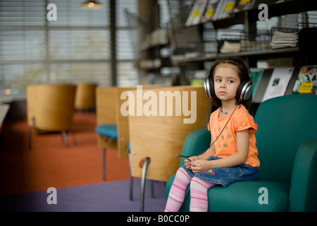 Zentrale Bibliothek Palmerston North New Zealand vier Jahre alten Mädchen hört Radiosendungen über Kopfhörer Stockfoto