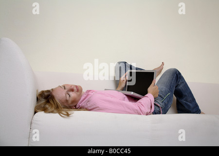 Frau mit Laptop auf dem sofa Stockfoto