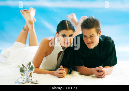 Paar auf Bauch, mit gekreuzten Beinen liegend Stockfoto