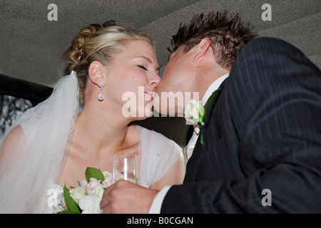Braut und Bräutigam küssen im Hochzeitsauto Stockfoto