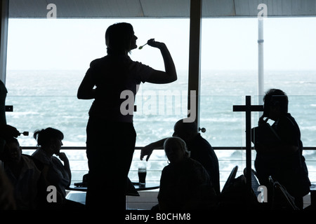 Silhouette einer weiblichen Dartspieler Konzentration auf Pfeile zu werfen, während ein Damen-Dart-Turnier Stockfoto