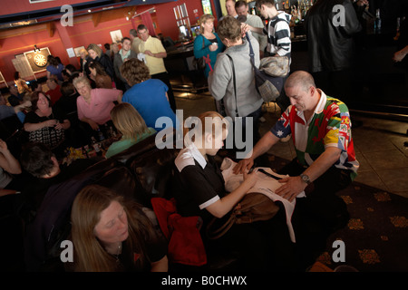 Damen Darts Champion Anastasia Dobromyslova unterschreibt ihr Autogramm auf einem Shirt für einen männlichen Dart-Fan während England Open Turnier Stockfoto