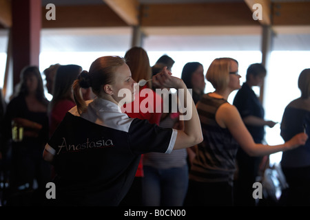 Damen darts Champion Anastasia Dobromyslova konzentriert sich auf werfen Darts umgeben von Amateur-Spieler bei ihrem Turnier Stockfoto