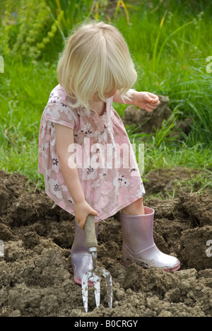 Stock Foto von einem kleinen blonden Haaren zwei Jahre alten Mädchen bei der Gartenarbeit helfen Stockfoto