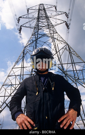 Mitglied einer nationalen Grid-Live-Line Kabel Wartung Crew steht unter einem Strommast in nichtleitendes Sicherheitskleidung Stockfoto