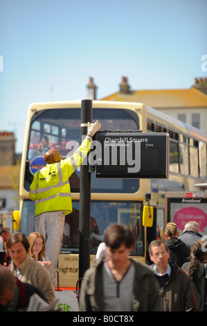 Ein Arbeiter eine Bushaltestelle in Churchill Square, Brighton Malerei. Bild von Jim Holden. Stockfoto