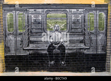 Glatzköpfiger Mann sitzt auf Rohr, trainieren - ein Bild von The Cans Festival, eine Londoner Ausstellung Graffito Straßenkünstler half Banksy öffnen Stockfoto