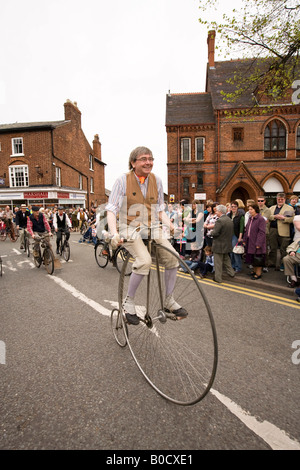 UK Cheshire Knutsford Royal Maifeiertag Prozession Mann reitet Hochrad Oldtimer Motorrad Gruppe Stockfoto