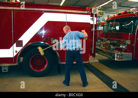 Reinigung der Reifen auf Feuerwehrauto Feuerwehrmann Stockfoto