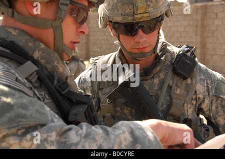 U S Army Staff Sgt Terry Goble links Slips Sgt Robert Klotz vor einer gemeinsamen Patrouille durch eine Nachbarschaft in a. Irak Stockfoto