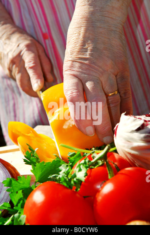 Hände einer älteren Frau, Schneiden von frischem Gemüse Stockfoto