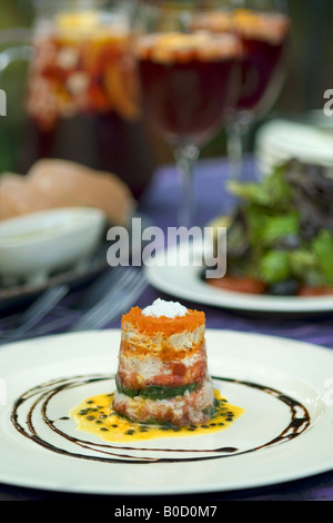 Krabben-Timbale, Salat mit Vinaigrette und roten Wein Sangria auf ein Esstisch im Freien in Spanien. Stockfoto