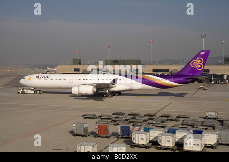 Thai Airways International Airbus A340-600 geschleppt wird zu seinem Gate am Flughafen Zürich mit Air Cargo Container im Vordergrund. Stockfoto