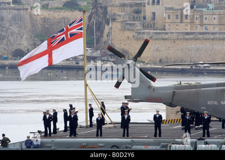 Die Royal Navy Flugzeugträger HMS Illustrious bei der Ankunft in Grand Malta's Hafen mit Segler ständigen Aufmerksamkeit unter dem weißen Stern Stockfoto