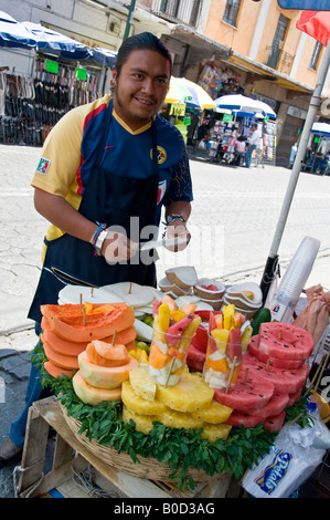 Mexikanische Mann verkaufen geschnitten, Papayas, Melonen, Kokosnuss und Ananas, zum Verkauf an Straßenecke in Puebla, Mexiko. Stockfoto