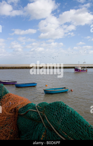 kleine Boote und Fischerboot in Folkestone Hafen mit Fischernetzen zum Trocknen auf Geländer im Vordergrund Stockfoto