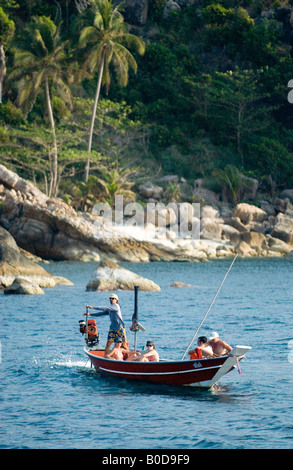 Touristen genießen Sie einen Tagesausflug auf einem thailändischen Longtail-Fischerboot um einen der vielen tropischen Inseln im Süden Thailands Stockfoto
