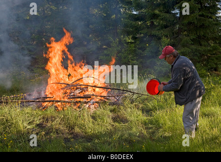 Ein Mann wirft Wasser, Feuer, Finnland Stockfoto