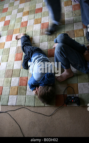 Junge legt sich auf den Boden, frustriert durch Video-Spiel Stockfoto