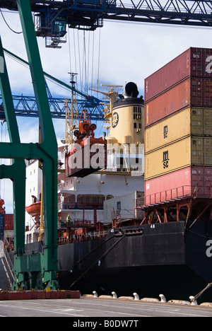 Ein Container-Kran lädt Container auf einem Schiff in Lyttelton, Neuseeland Stockfoto