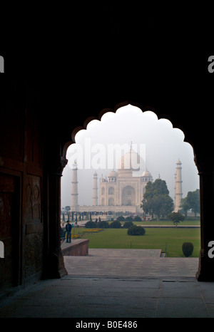 Indien AGRA Taj Mahal Denkmal gesehen durch einen Torbogen im Morgennebel bei Sonnenaufgang als indische Touristen-tour Stockfoto